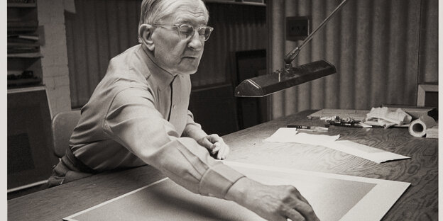 Josef Albers arbeitet an seinem Schreibtisch sitzend an einem Quadrat