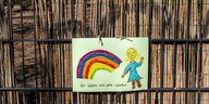 Kinderzeichnung eines Regenbogens und einer Person, die winkt