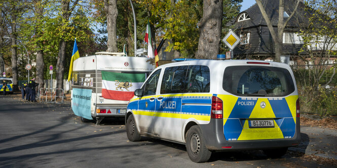 Ein Polizeiauto steht neben einem Wohnwagen auf der Straße