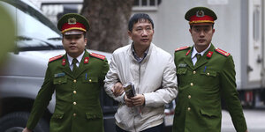 Trinh Xuan Thanh wird von zwei vietnamesischen Polizisten eskortiert