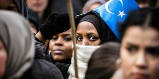 Uigurinnen protestieren mit der Fahne Ostturkestans