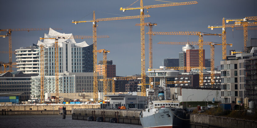 Ein Schiff liegt am Kai vor der Hamburger Hafencity mit Kränen