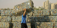 Ein Ägypter stapelt Pakete gepresster Plastikflaschen