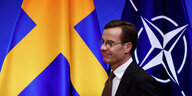 Schwedens neuer Regierungschef Ulf Kristerrson for den Flaggen Schwedens und der Nato im Nato-Hauptquartier in Brüssel am 20. Oktober 2022.