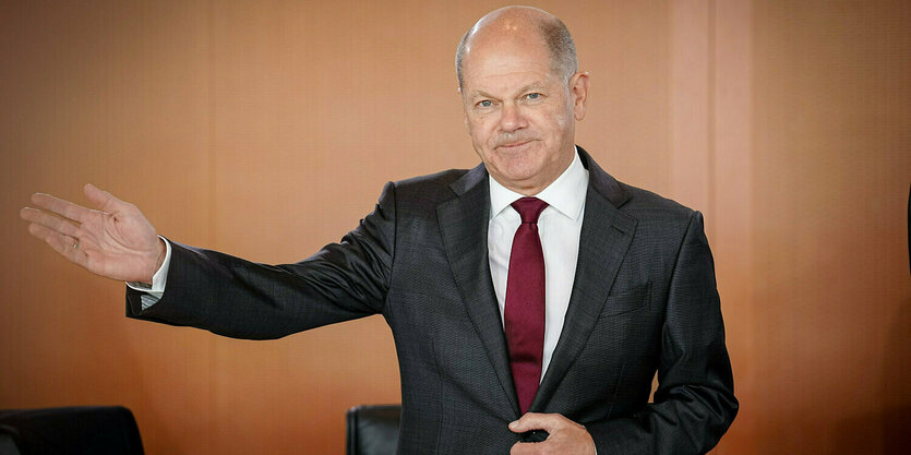 Olaf SCholz streckt einen Arm aus