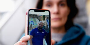 Im Vordergrund ein Handy mit Foto von Pablo González, im Hintergrund seine Ehefrau