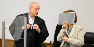 Die Angeklagte steht mit Handschellen im Saal vom Landgericht neben ihrem Verteidiger Norbert Lösing.