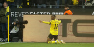 Der Dortmunder Fußballprofi Youssoufa Moukoko kniet vor den Fans und jubelt