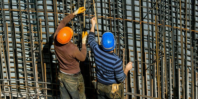 Zwei Eisenbieger binden auf einer Baustelle in Nordrhein-Westfalen Moniereisengeflechte für die Armierung von Betonteilen.