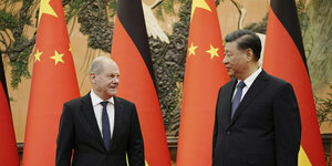 Kanzler Scholz und Chinas Präsident Xi vor chinesischen und deutschen Fahnen