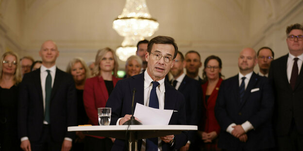 Sweden's Prime Minister Kristersson stands at a lectern
