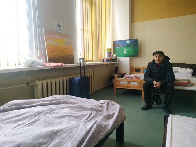 Viktor Borsch sitzt auf einem Bett in einem Mehrbettzimmer in der Erstaufnahme in Narva Viktor Borsch sitzt auf einem Bett in einem Mehrbettzimmer in der Erstaufnahme in Narva