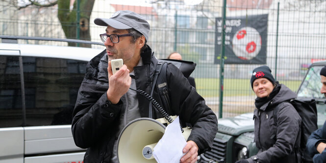 Martin Kaltwasser mit einem Megafon in der Hand auf einer Straße