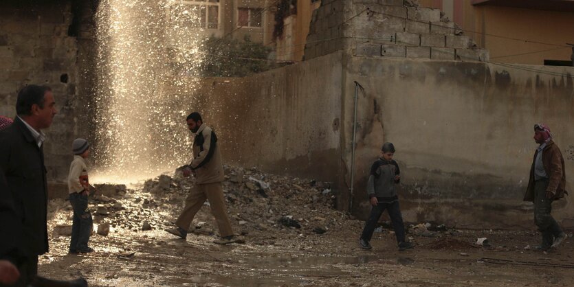 Menschen laufen durch Trümmer im syrischen Duma.