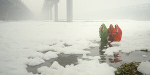 Szene aus einem Dokumentarfilm über Klimawandel, Menschen laufen durch eine Landschaft voller weißer Schaumkronen.