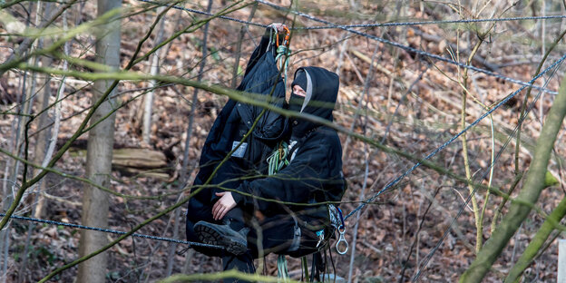 Ein Besetzer bewegt sich an einem Seil entlang durch den Wald