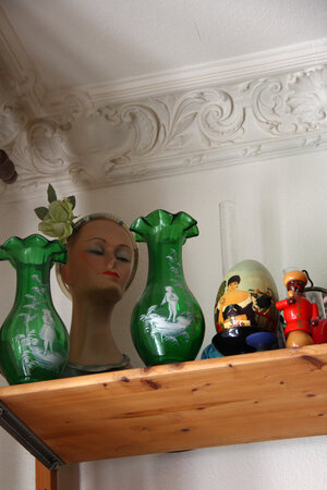 Auf einem Regalbrett stehen Vasen, kleine Figuren und eine Büste Auf einem Regalbrett stehen Vasen, kleine Figuren und eine Büste