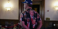 Ein Mann mit einem Hemd voller Fotos von Donald Trump