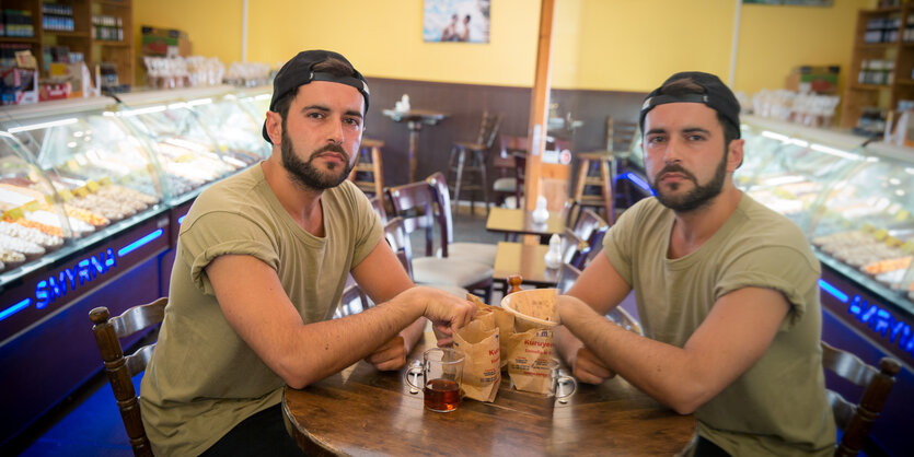 Rapper Chefket sitzt mit seinem Spiegelbild am Tisch