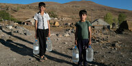 Kinder tragen Wasserkanister