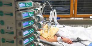 Ein Patient am Beatmungsgerät, vor ihm stehen viele Geräte