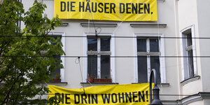 Banner an einem Haus: "Die Häuser denen die drin wohnen"