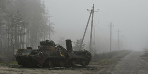 Zerstörtes Panzerfahrzeug im Nebel.
