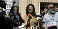 Sanaa Seif vor Mikrofonen bei einer Pressekonferenz.
