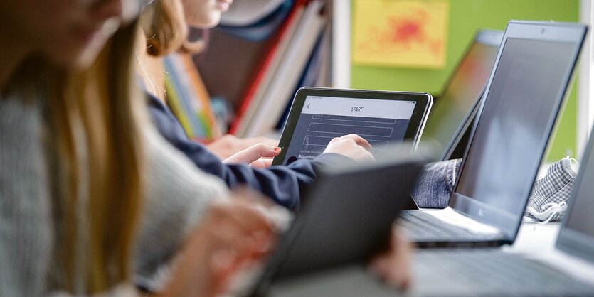 Zwei Schülerinnen tippen auf einem Tabelt-Computer