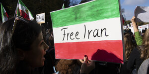 Teilnehmer der Großdemonstration "Solidarität mit den Protestierenden im Iran" stehen am Startpunkt, am Großen Stern in Berlin