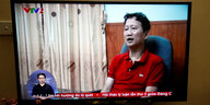 Trinh Xuan Than im roten Shirt ist in einem Fernsehbildschirm zu sehen