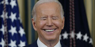 Präsident Joe Biden lächelt.