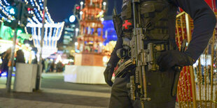 Polizist mit Maschinengewehr am Weihnachtsmarkt