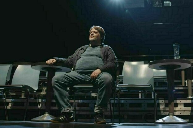 Regisseur Georg Genoux sitzt in einem leeren Theaterraum Regisseur Georg Genoux sitzt in einem leeren Theaterraum
