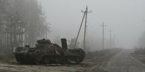 Ein zerstörter Panzer steht am Rand einer Straße