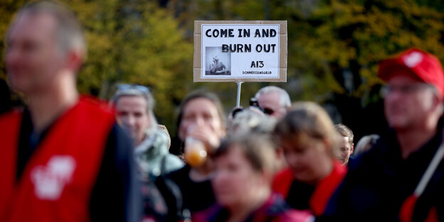 „Come In And Burn Out“ und „A13 Schmerzensgeld“ steht auf einem Transparent während eines Protestes von Grundschullehrerinnen und -lehrern aus Sachsen-Anhalt vor dem Landtag in Magdeburg