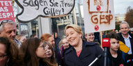 Franziska Giffey steht neben protestierenden Schüler*innen mit Transparenten