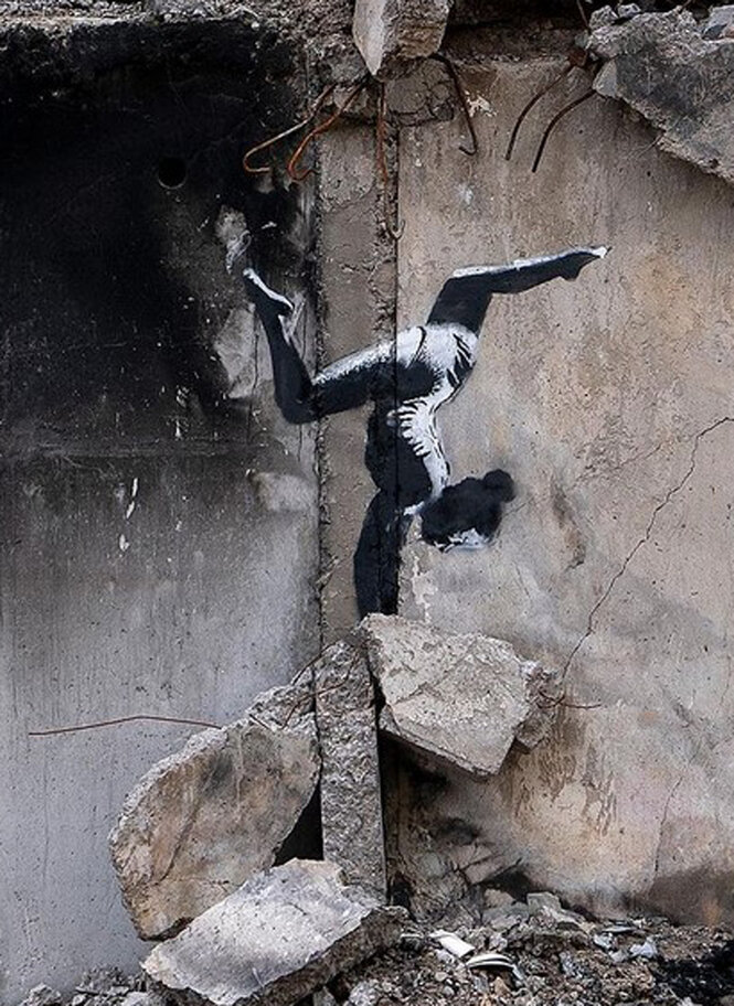 Banksy-Graffti einer Tänzerin, die auf Ruinengestein eine Art Handstand macht