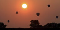 Heißluftballons im sonnendurchfluteten Himmel