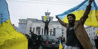 Ein Mann reckt eine Ukraine-Fahne in die Höhe