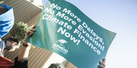 Ein Klimaaktivist hält ein Schild hoch bei einem Protest gegen fossile Brennstoffe während der UN-Klimakonferenz COP27.