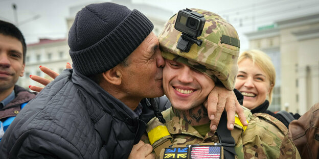 Ein Zivilist in Cherson umarmt und küsst einen ukrainischen Soldaten