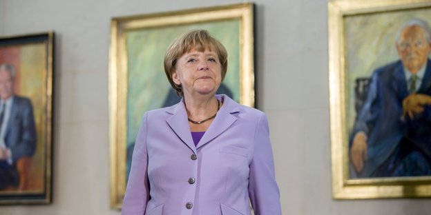 Angela Merkel steht vor Bildern von ehemaligen Kanzlern
