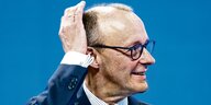 CDU-Chef Merz fasst sich an seinen Kopf und trägt eine Brille