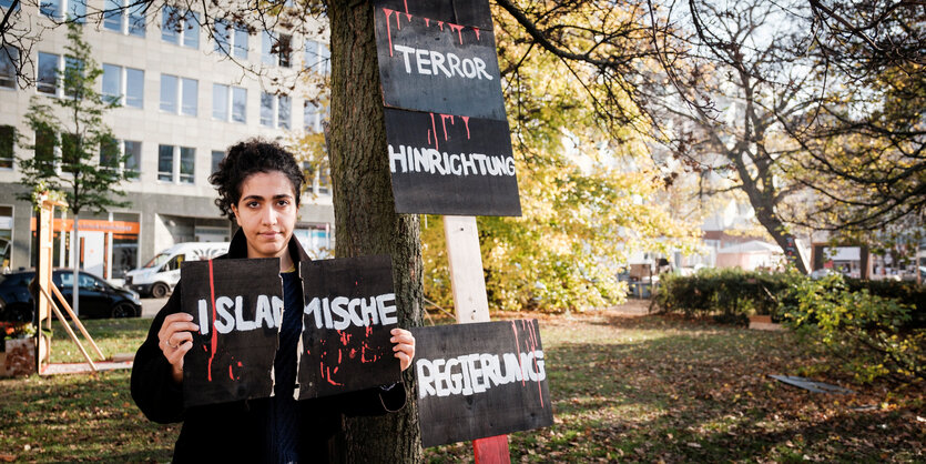 Setayesh von der Gruppe Feminista.Berlin zeigt das zerstörte Protest-Schild