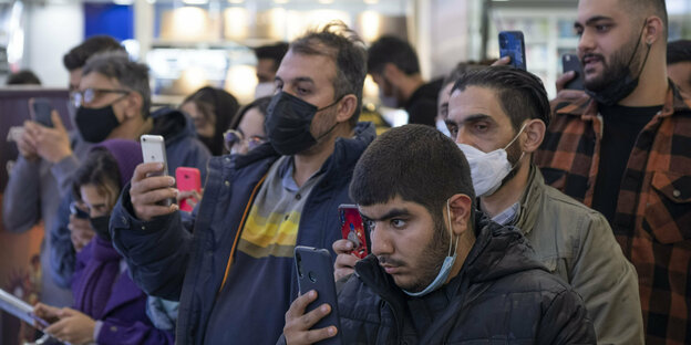 Menschen im Iran halten ein Smartphone und machen ein Video