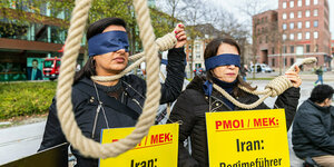 Zwei Frauen demonstrieren mit verbudnen Augen gegen die Todesstrafe, vor ihnen hängt ein Strick