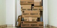 Viele Amazon Pakete stehen vor einer Wohnungstür