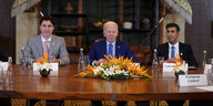 Justin Trudeau, Joe Biden und Rishi Sunak an einem mit Blumen geschmückten Tisch
