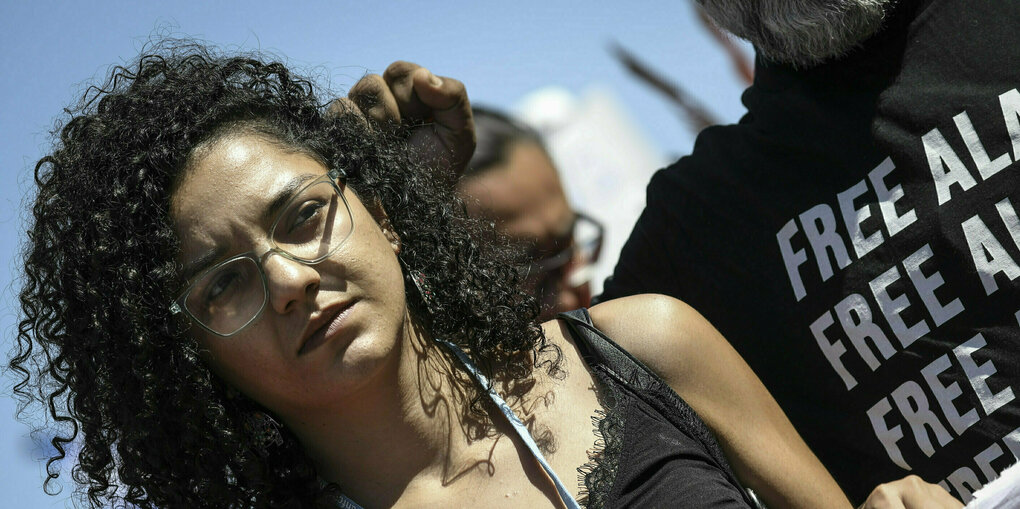 Sanaa Seif mit schwarzen Locken und einem schwarzen Shirt bei einer Demonstration